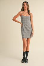 Load image into Gallery viewer, Woman wearing a plaid dress with a beige background
